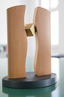 auf dem Tisch steht eine handgefertigte Plastik aus Holz auf einem ovalen Sockel, hergestellt von Künstler Tobias Dingler