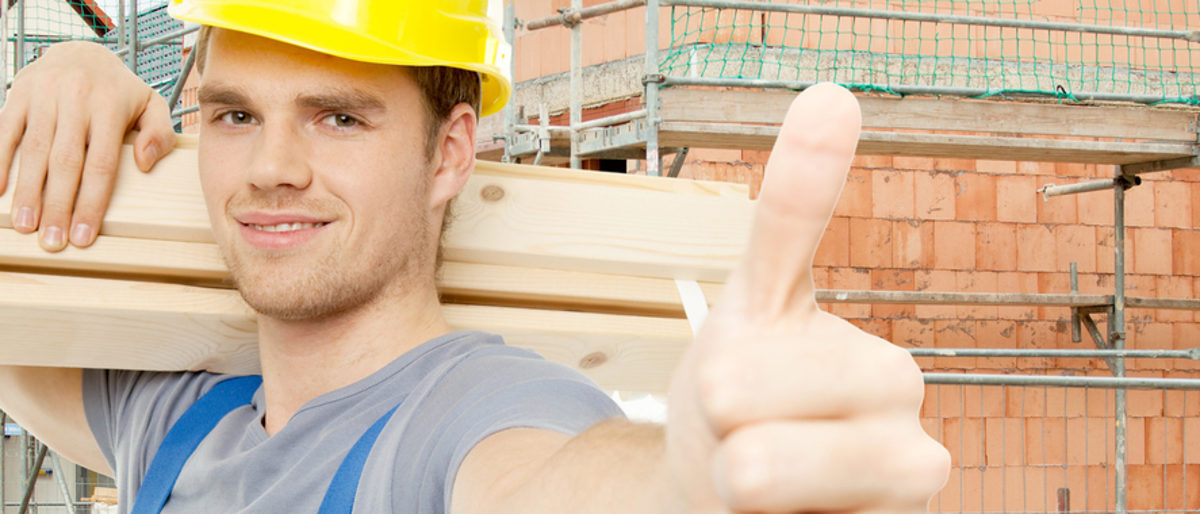 Mit der Checkliste die Existenzgründung erfolgreich meistern Handwerker auf der Baustelle blickt in die Kamera und hält den Daumen hoch