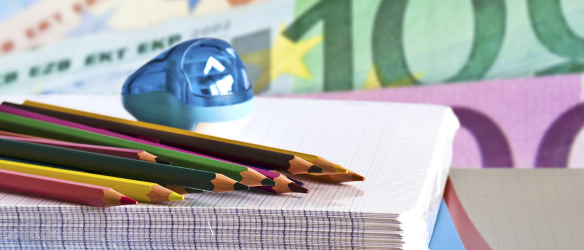 Mit einem Stipendium können Handwerker die Weiterbildung finanzieren. Buntstifte und Spitzer liegen auf einem Block Papier. Im Hintergrund sind Euroscheine zu erkennen.