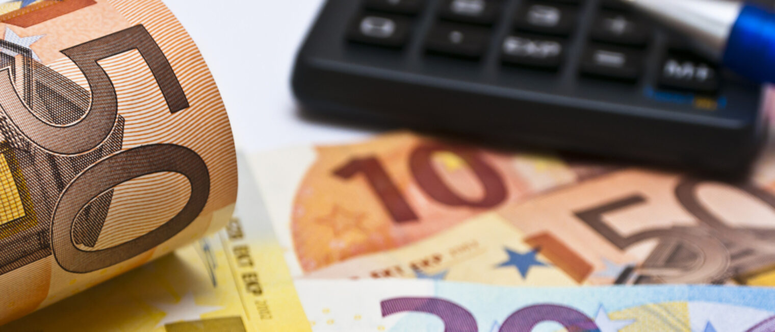50 Euro Geldscheine, ein Taschenrechner und ein Stift 
