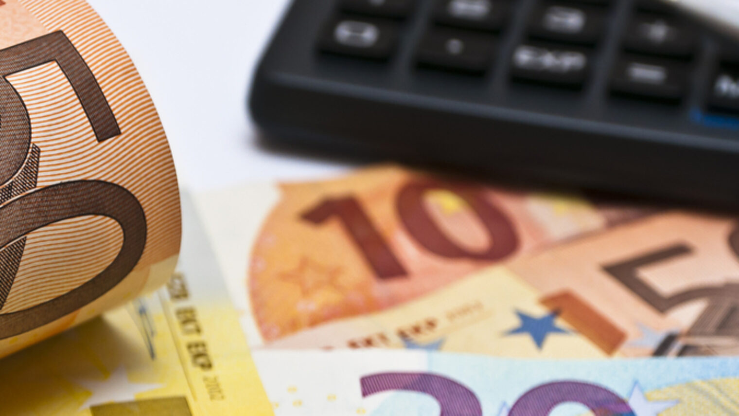 50 Euro Geldscheine, ein Taschenrechner und ein Stift 