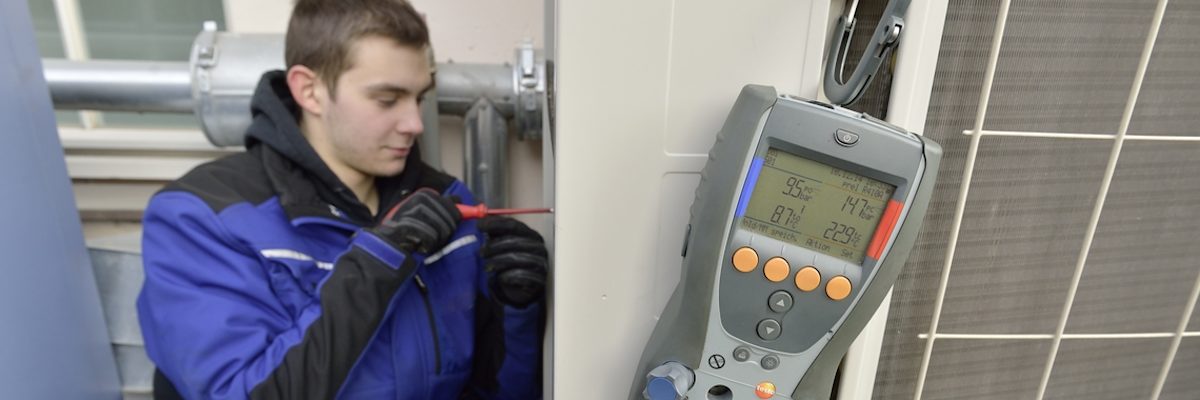 Mann in Arbeitskleidung blau, Messgerät, Schraubenzieher
