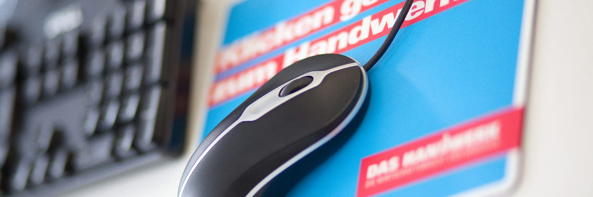 Der Initiative handwerkskammer.de gehören alle Handwerkskammer an. Computermaus auf einem blau-roten Mauspad. Im Hintergrund ist eine Computertastatur unscharf zu sehen.