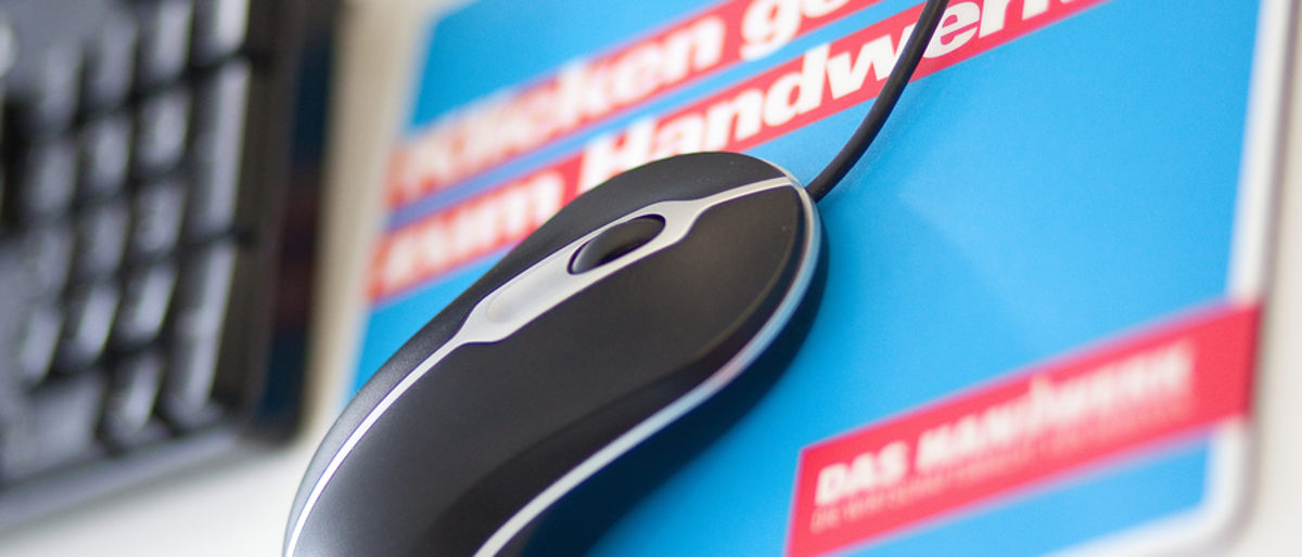 Der Initiative handwerkskammer.de gehören alle Handwerkskammern an. Computermaus auf einem blau-roten Mauspad. Im Hintergrund ist eine Computertastatur unscharf zu sehen.