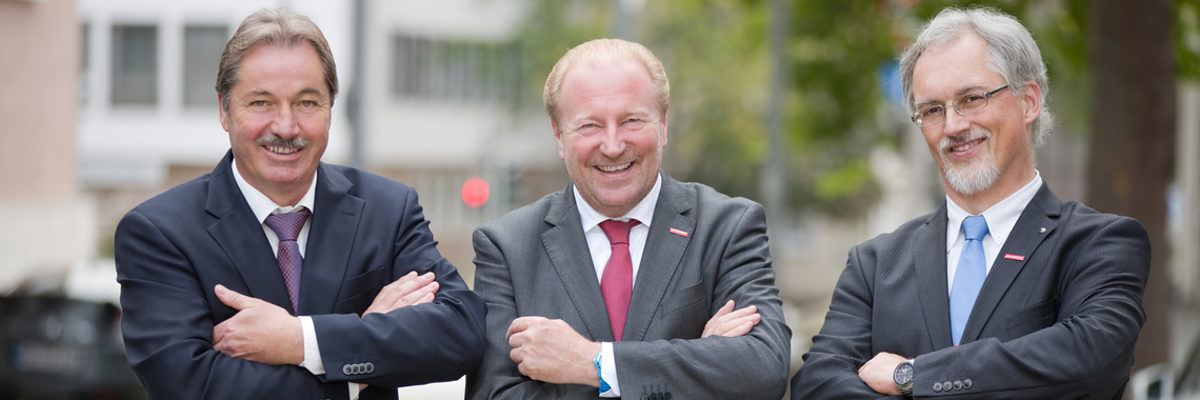 Präsidium der Kammer: Kurt Georg Schreiber, Ulrich Bopp, Markus May. Drei Männer in Anzug in Krawatte stehen mir verschränkten Armen nebeneinander und lachen in die Kamera.