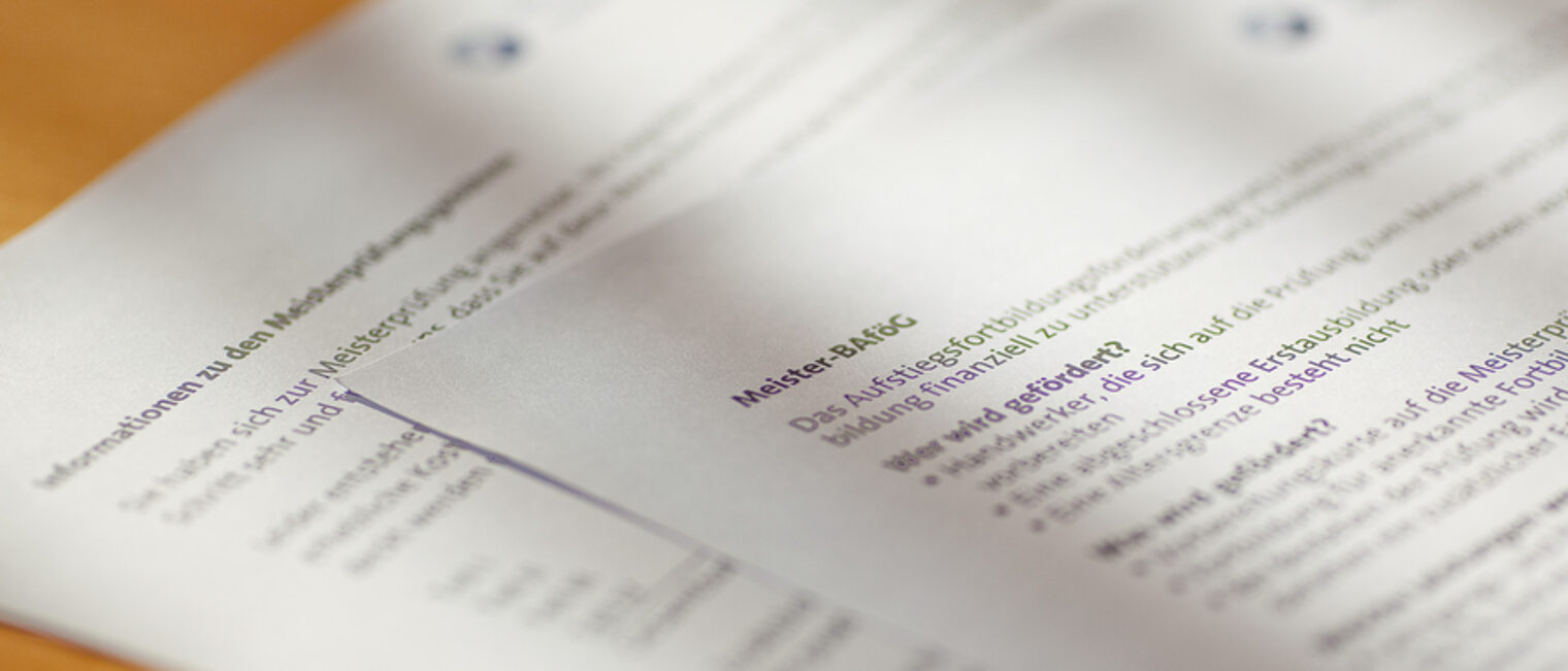 In den Verordnungen finden Sie unter anderem die Prüfungsanforderungen. Zwei Blätter mit Informationen zur Meisterprüfung liegen auf einem Schreibtisch.