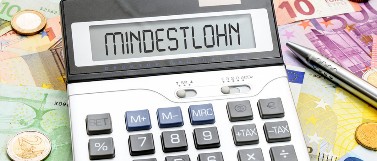 Mindestlohn: Generalunternehmer haften für Subunternehmer Ein Taschenrechner, dessen Display anzeigt: "Mindestlohn", liegt zwischen Euro-Scheinen und Münzen.