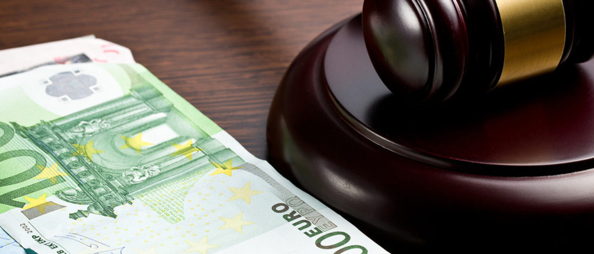 Unbezahlte Rechnungen können Handwerksbetriebe schnell in finanzielle Schwierigkeiten bringen. Ein Hundert-Euro-Schein und ein Zwanzig-Euro-Schein liegen neben einem Richterhammer.