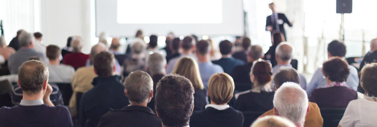 Informationsveranstaltung der Handwerkskammer Heilbronn-Franken viele Menschen sitzen in einem Raum, schauen nach vorne und hören einem Moderator zu.