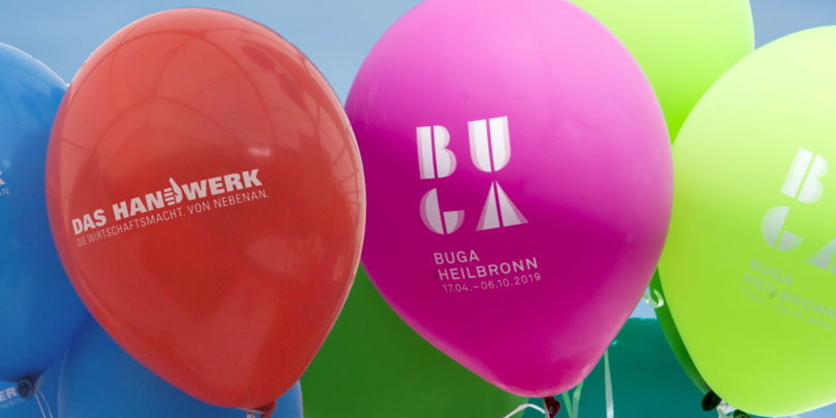 Bunte Ballons mit Schriftzügen "DAs Handwerk" und "BUGA" vor einem blauen Himmel.