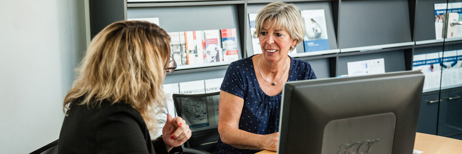 Zwei Frauen sitzen bei einem Beratungsgespräch an einem Tisch.