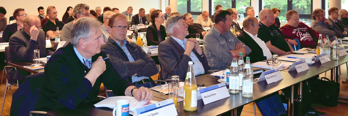 Die Vollversammlung der Handwerkskammer tagte am 8. Mai 2019. Männer und Frauen sitzen an langen Tischreihen. Sie haben Namensschilder un Getränke vor sich stehen.