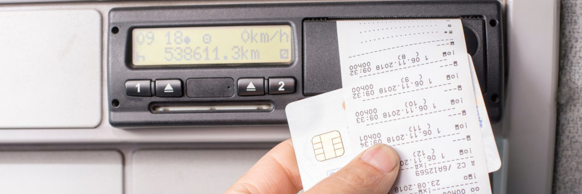 Änderung bei der Fahrtenschreiber-Pflicht im Handwerk. Digitaler Tachograf, Fahrtenschreiber, Fahrer hält Karte und Ausdruck des Fahrenschreibers in der Hand