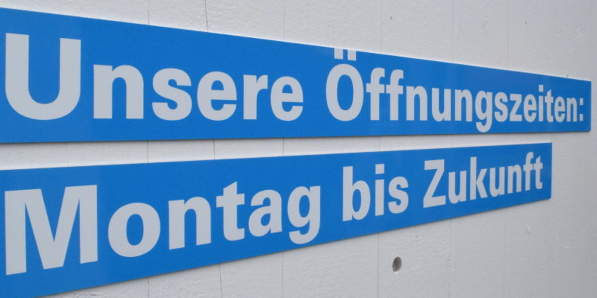 Diese Termine erwarten BUGA-Besucher im Pavillon des Handwerks. Zwei blaue Leisten an einer weißen Wand. Darauf steht in weißer Schrift: Unsere Öffnungszeiten: Montag bis Zukunft