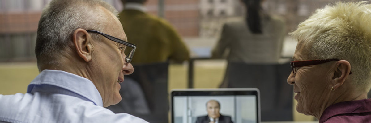 Kostenfreie Online-Seminare für Handwerker. Ein Mann und eine Frau sitzen gemeinsam vor einem Laptop und verfolgen ein Webinar
