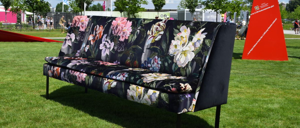 Exklusiv für die BUGA mit blumigen Stoff von Designer Guild bezogen. Auf der BUGA steht in der Wiese ein großes modernes Sofa, bezogen mit weichem blumenstoff von Designers Guild