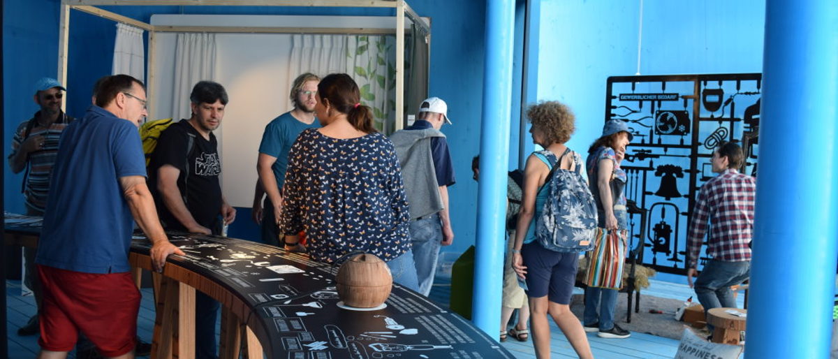 Marcus Bleyer (li.) im Gespräch mit den Pavillion-Besuchern. viele Besucher stehen im Pavillion des Handwerks, Handwerker und Besucher im Gespräch