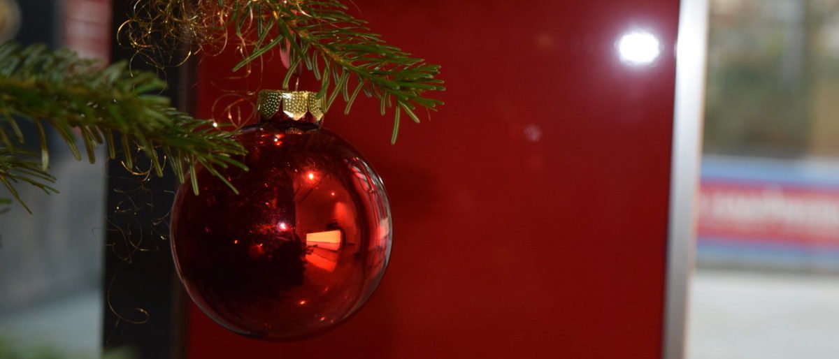Die Handwerkskammer wünscht allen frohe Weihnachten. Rote Weihnachtskugel am Tannenbaum.