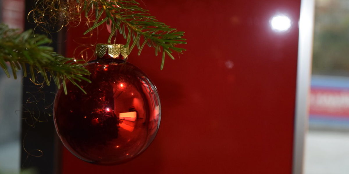 Die Handwerkskammer wünscht allen frohe Weihnachten. Rote Weihnachtskugel am Tannenbaum.