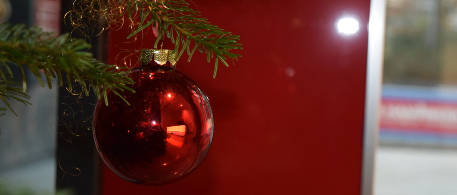 Rote Weihnachtskugel am Tannenbaum.