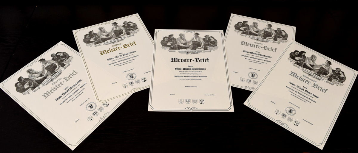 Handwerksmeister können auch einen Schmuck-Meisterbrief bestellen. Auf dunklem Hintergrund liegen fünf Meisterbriefe in silber, gold, schwarz, diamant, eisern, die historisch gestaltet sind.