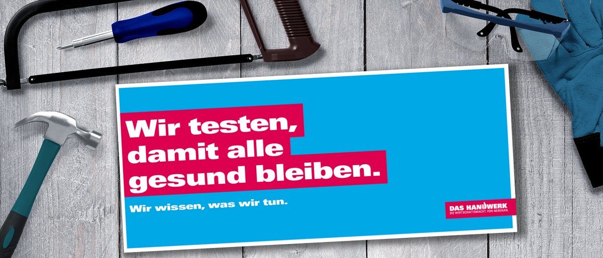 Informationen zu Testangeboten für Handwerksbetriebe. Karte mit Schriftzug "Wir testen, damit alle gesund bleiben" in weiß, auf roter Fläche und blauem Hintergrund, und Werkzeuge.