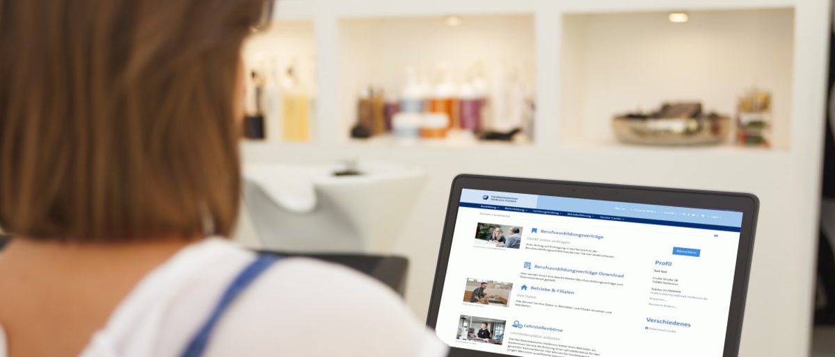 Digitales Dienstleistungsangebot durch Kundenlogin erweitert. Friseurin arbeitet am Laptop im Friseurgeschäft
