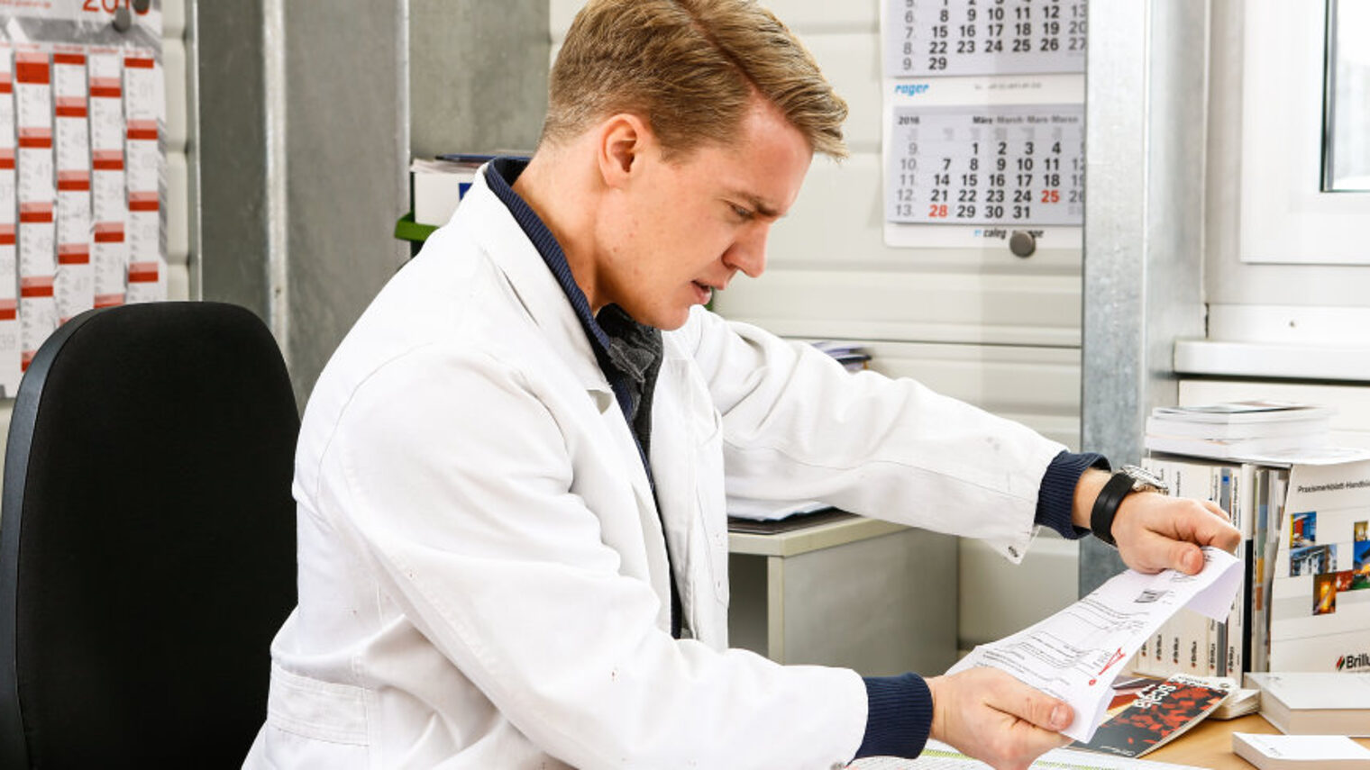 Handwerker sitzt am Schreibtisch und schaut verärgert auf einen geöffneten Brief