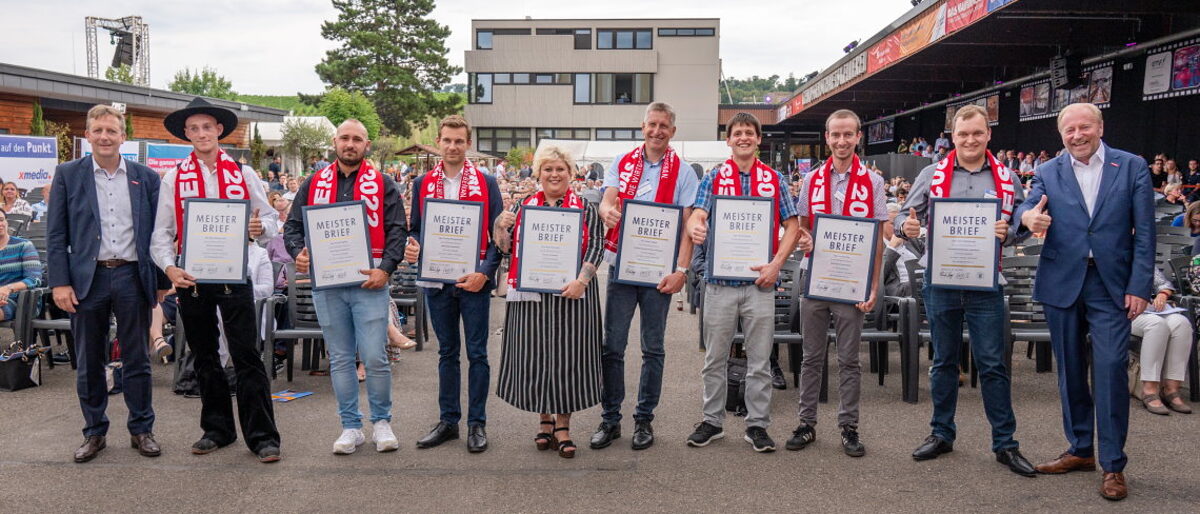 Die besten Meister 2022 mit Ralf Schnörr (li) und Ulrich Bopp (re). Gruppenfoto der acht glücklichen Meister mit ihrem Meisterschal und gerahmten Meisterbrief der Handwerkskammer.