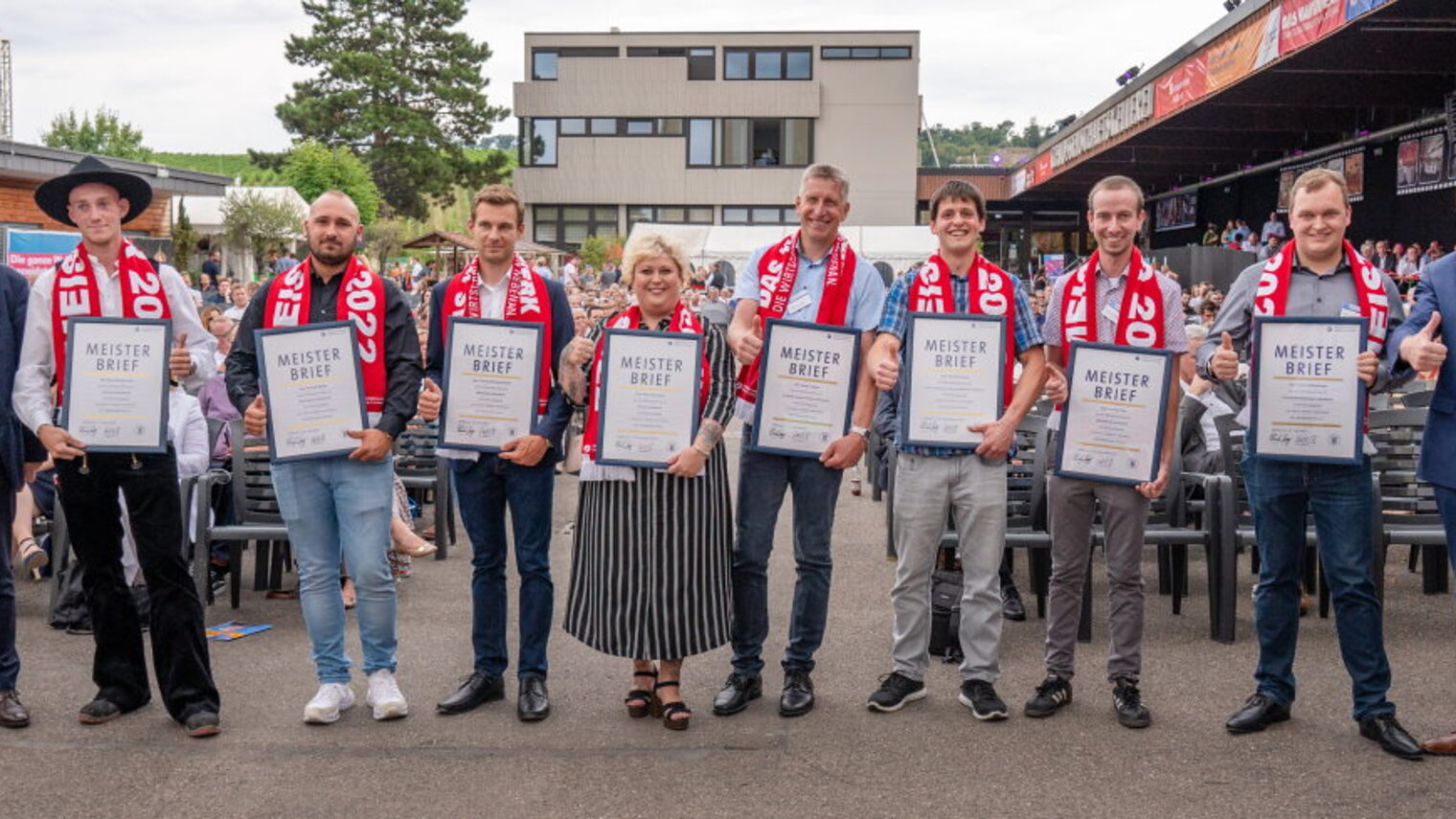 Gruppenfoto der acht glücklichen Meister mit ihrem Meisterschal und gerahmten Meisterbrief der Handwerkskammer.