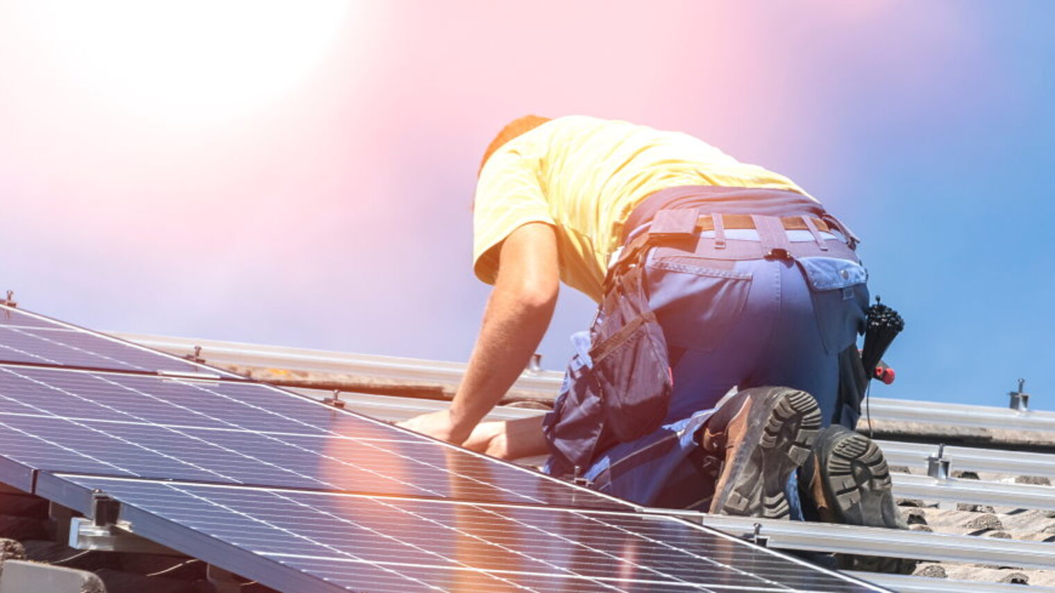 Handwerker installiert Photovoltaik-Panel auf einem Dach