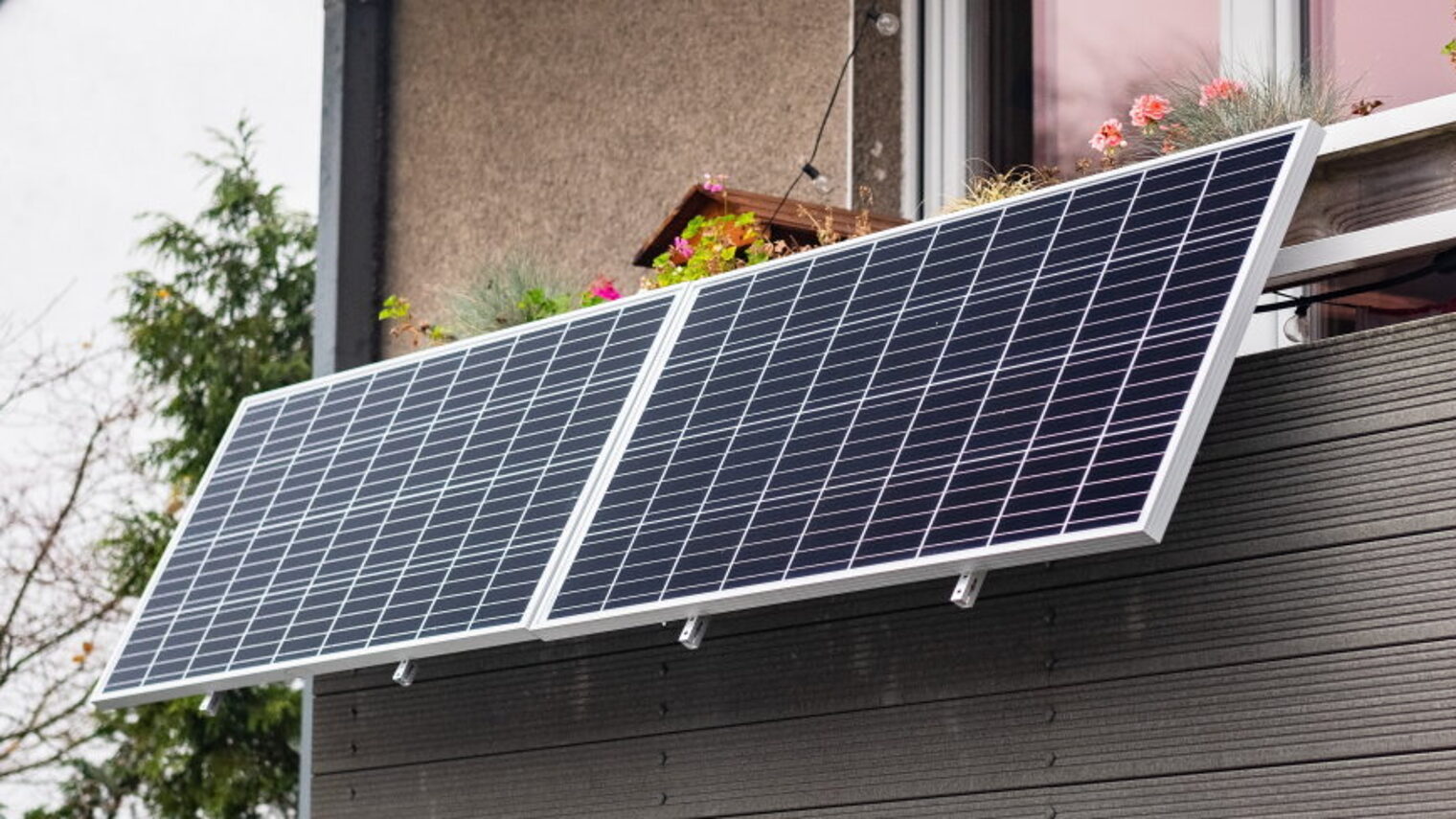 Balkon, an dem sich zwei Solarpanele befinden.