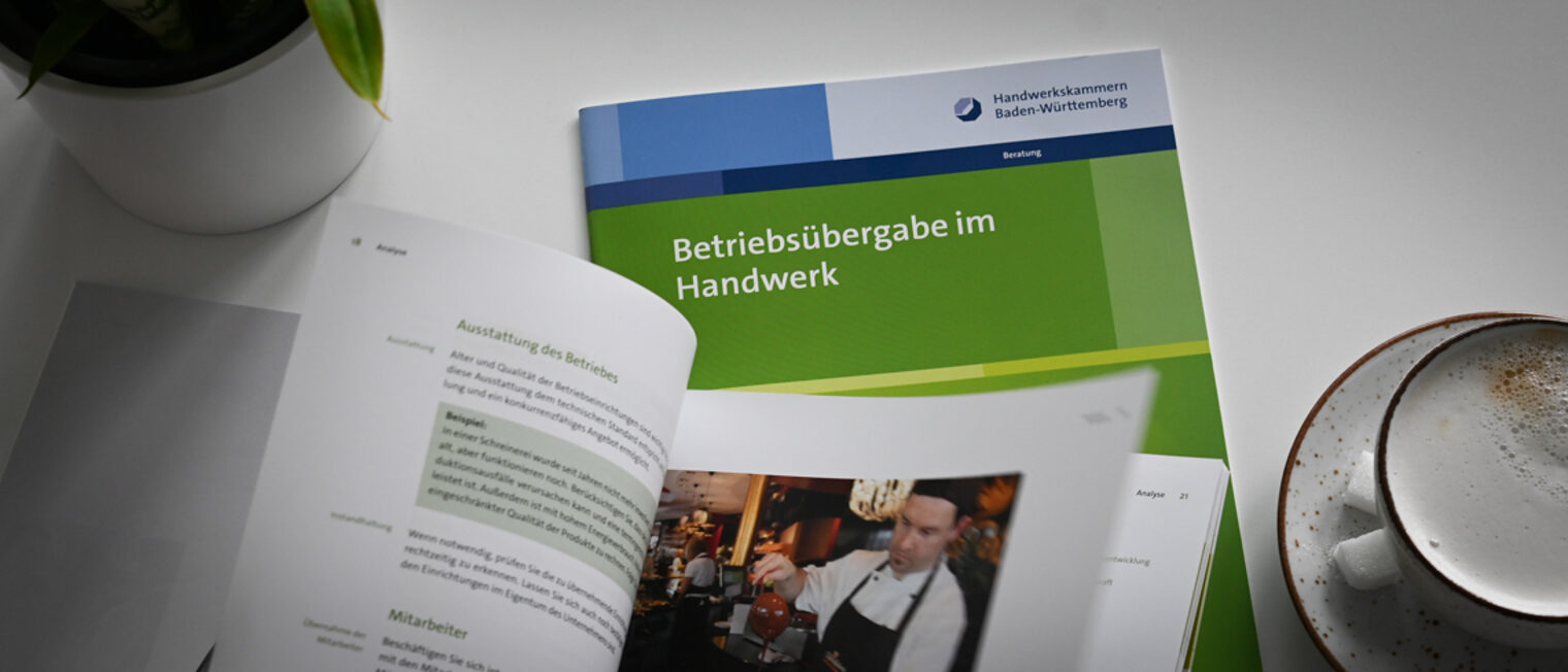 Eine Person blättert die Broschüre Betriebsübergabe