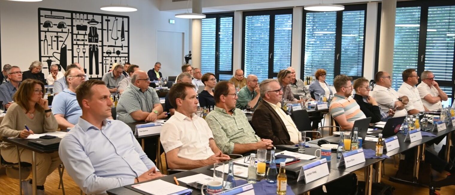 Die Vollversammlung: oberstes Be-schlussorgan und demokratisches Herzstück der Handwerkskammer. Rund 50 Menschen Sitzen in einem Saal an Tischreihen.