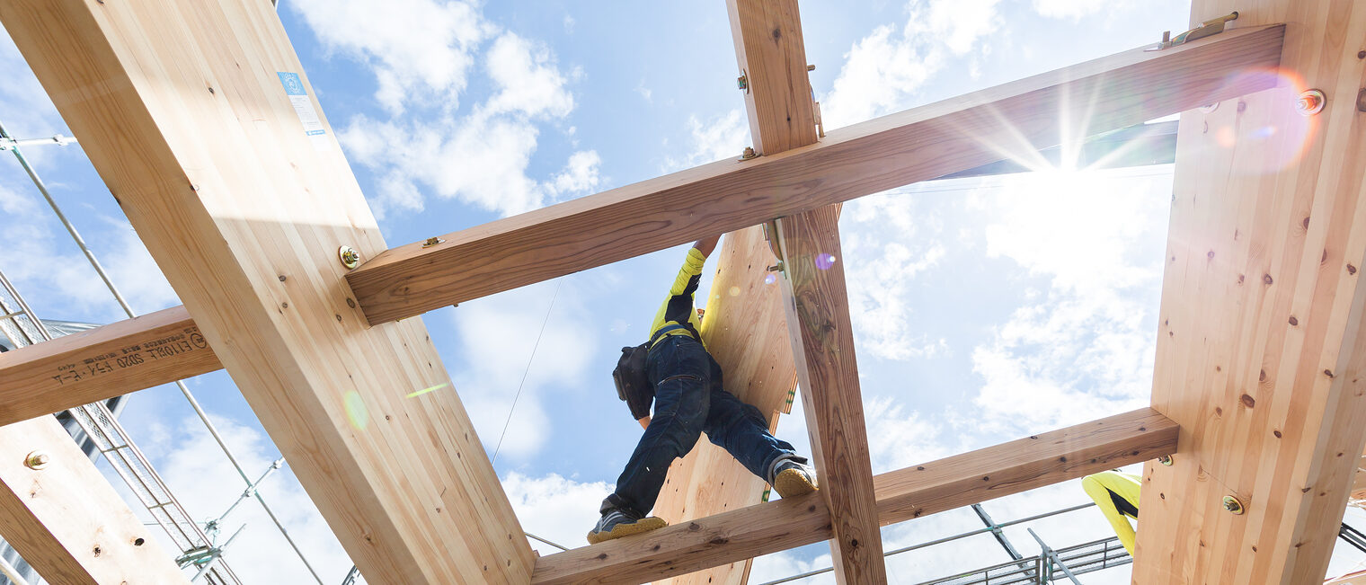 Ein Zimmerer arbeitet bei Sonnenschein auf einem Dachstuhl. Trotz leicht verbesserter Konjunktur wartet das Handwerk in der Region Heilbronn-Franken weiter auf eine Trendwende.