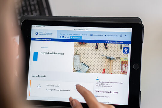 Eine Frau sitzt vor einem Tablet und hat sich in das Kundeportal der Kammer eingeloggt.