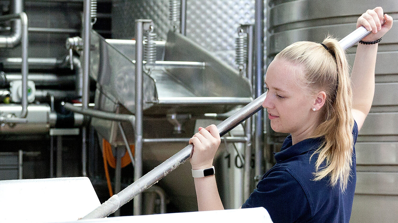 Eine Auszubildende zur Brauerin ist bei der Arbeit in einer Brauerei zu sehen.