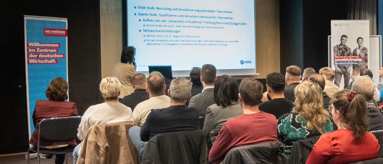 Eine Referentin spricht vor größerem Veranstaltungspublikum