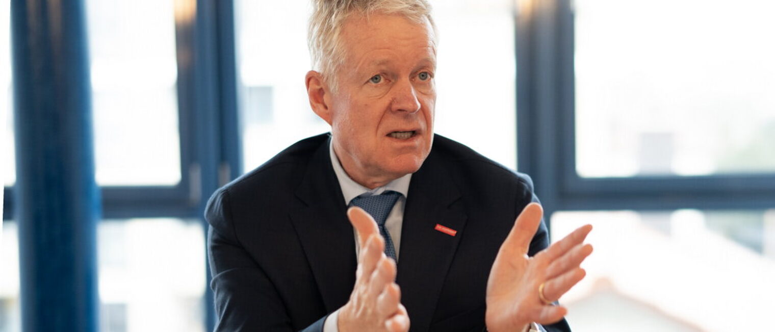 Ein Mann redet und gestikuliert mit den Händen. 