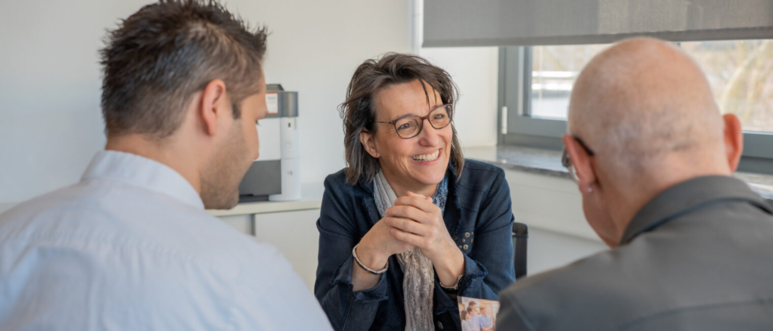 Unternehmensberaterin der Handwerkskammer im Gespräch mit einem Übergeber und einem Übernehmer.