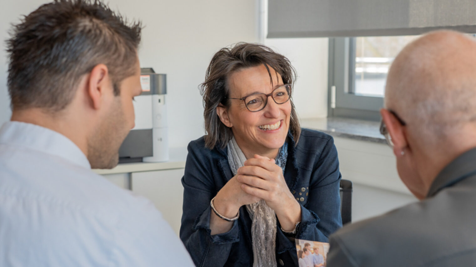 Unternehmensberaterin der Handwerkskammer im Gespräch mit einem Übergeber und einem Übernehmer.