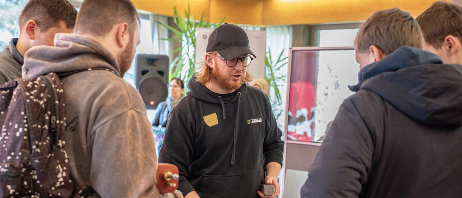 Ein Mann unterhält sich mit vier Jugendlichen. 