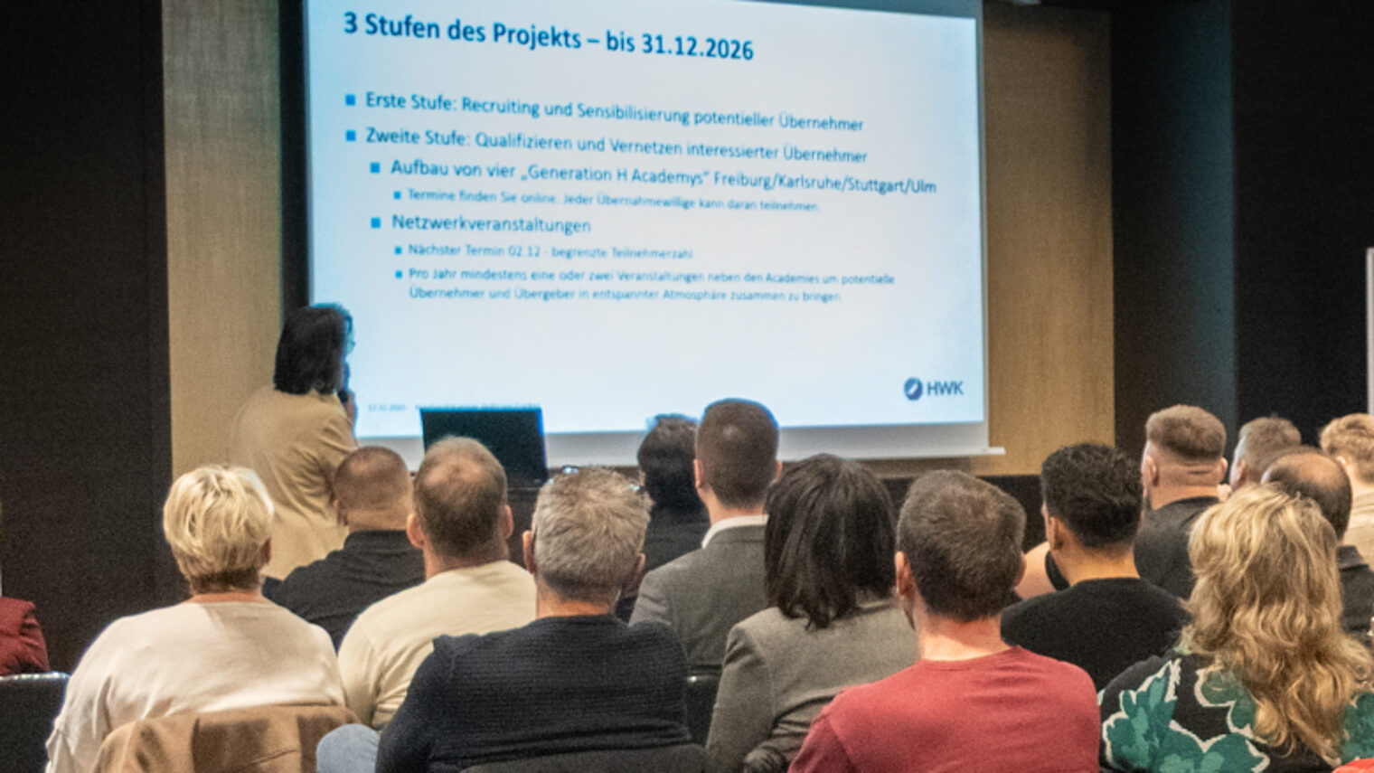 Referentin präsentiert vor einem größeren Publikum