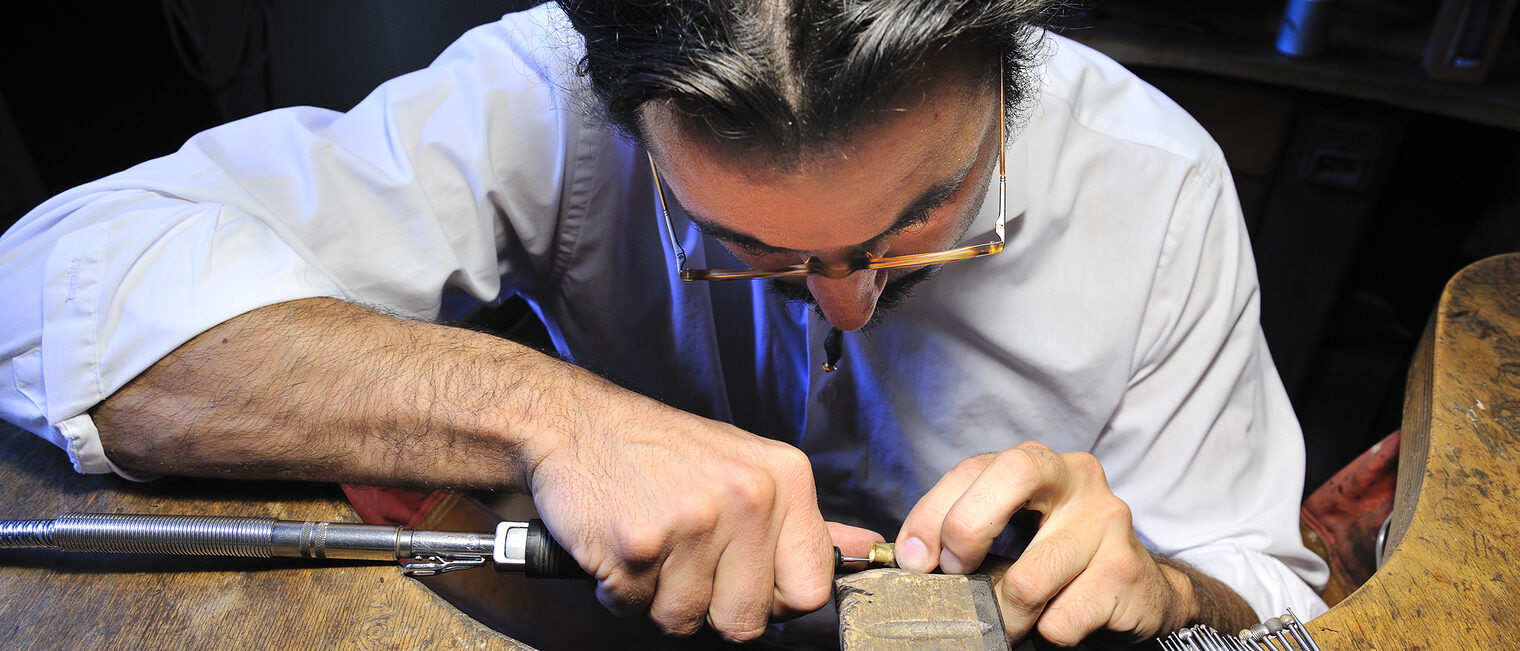 Ein Goldschmied arbeitet in seiner Werkstatt mit höchster Präzision.