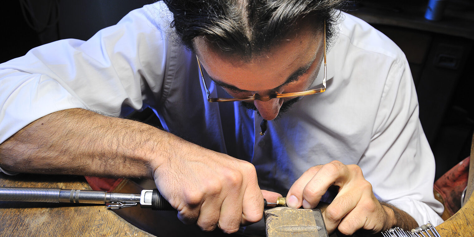 Ein Goldschmied arbeitet in seiner Werkstatt mit höchster Präzision.