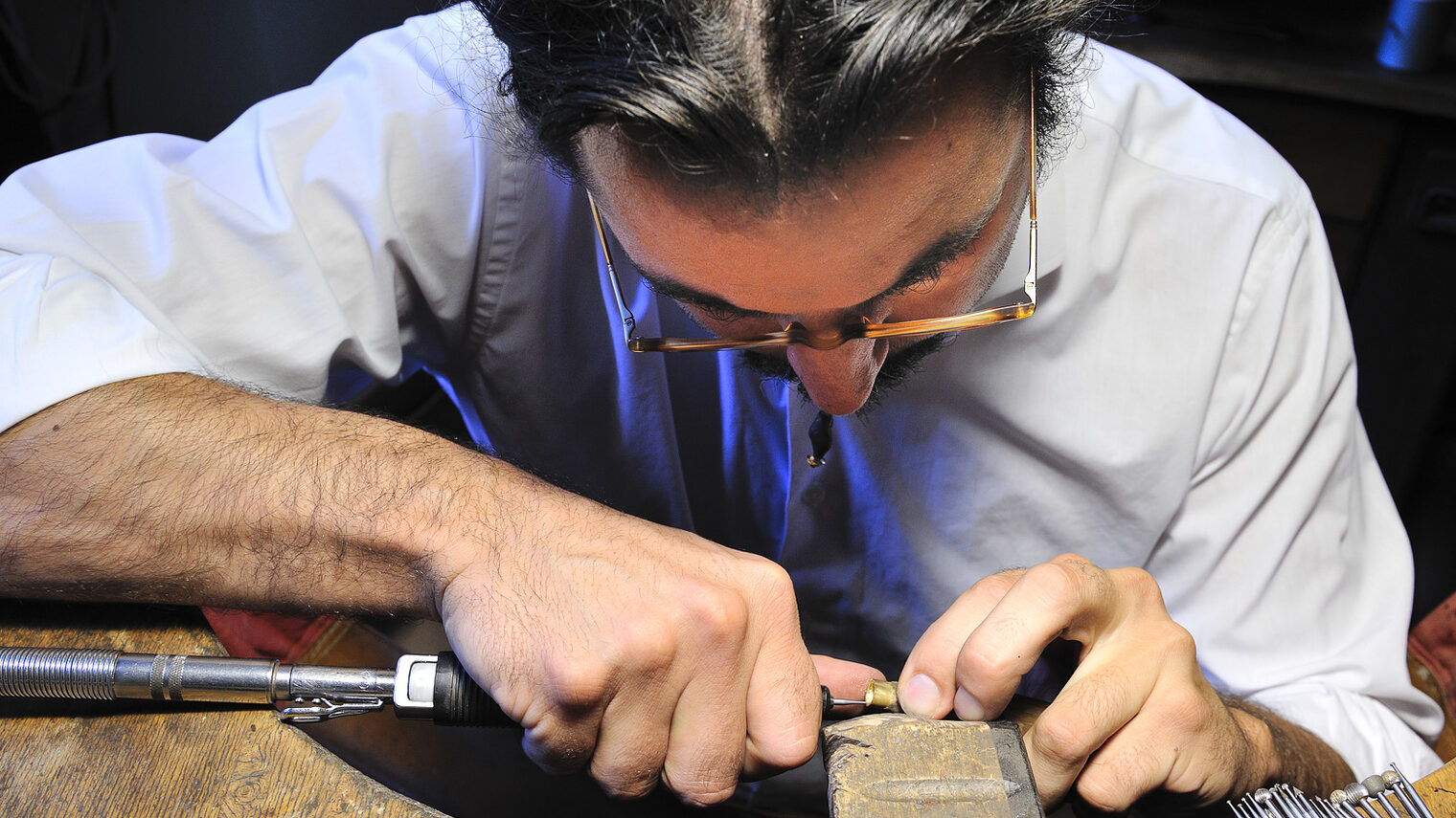 Ein Goldschmied arbeitet in seiner Werkstatt mit höchster Präzision.
